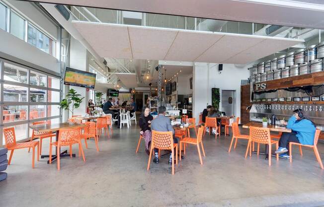 A group of people are sitting at tables in a brightly lit restaurant.