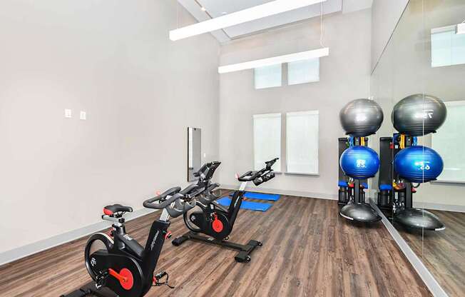 A gym with exercise bikes and a row of exercise balls.