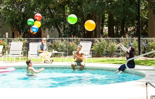 a group of people in a pool playing with balloons
