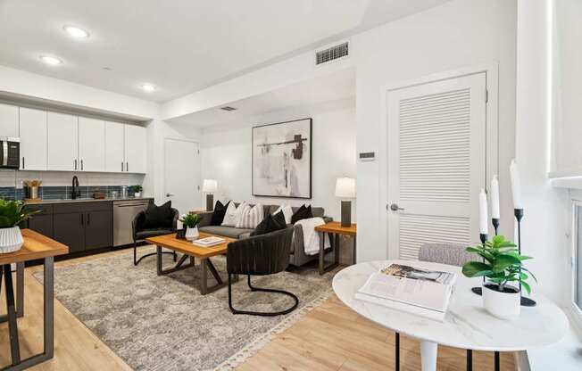 A modern living room with a black chair and a white table.