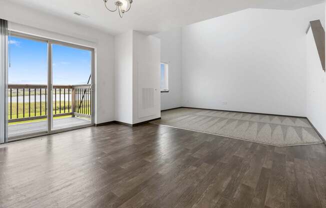 A room with a sliding glass door leading to a balcony.