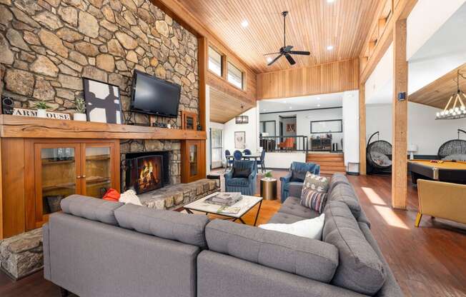 the living room has a large stone fireplace and a large couch