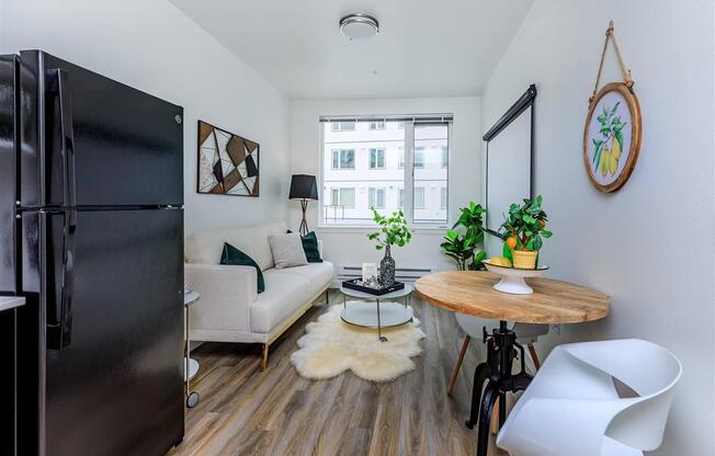 a small living room with a couch and a table with a chair at Jefferson Yards, Tacoma, WA