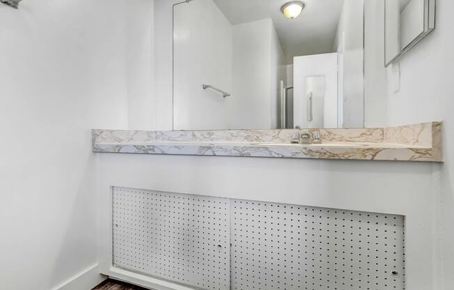 a bathroom with a mirror and a radiator on the wall