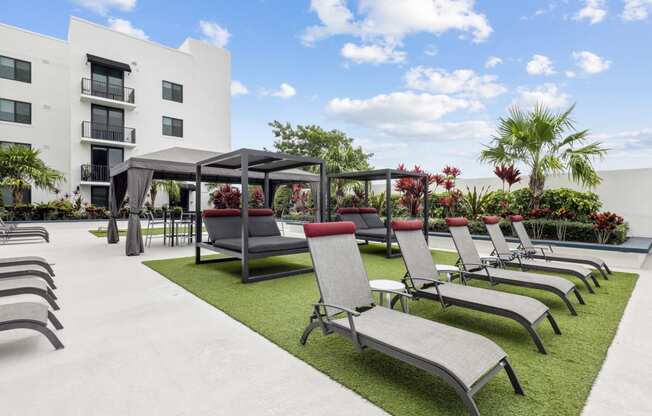 a row of lounge chairs and umbrellas in front of a building