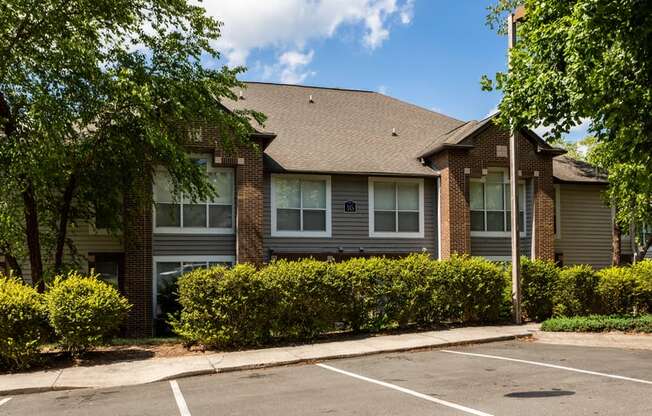 an apartment building with a parking lot in front of it