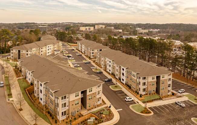 Apartment complex with a parking lot in front.