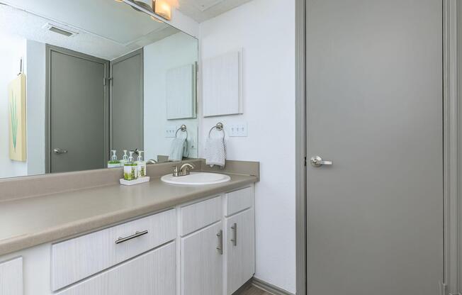 BRIGHT BATHROOM WITH MANY CUPBOARDS AND LONG COUNTER 