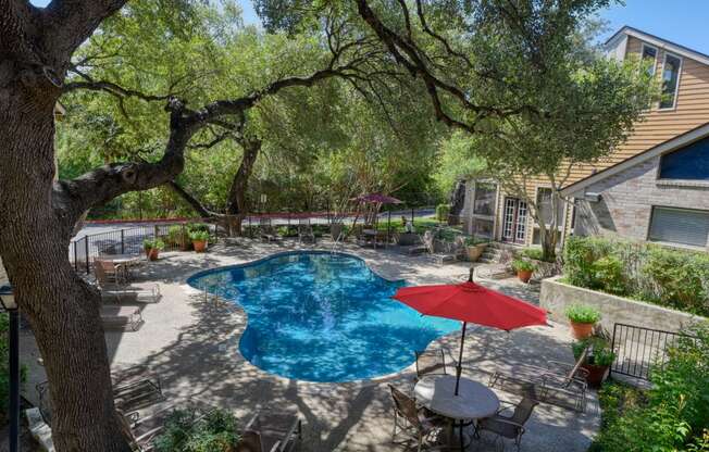 a backyard with a swimming pool and a patio with a table and chairs