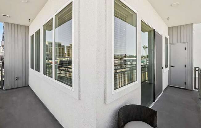 A white room with a black chair and a window overlooking a cityscape.