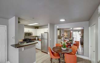 a kitchen and dining room with stainless steel appliances and a table and chairs