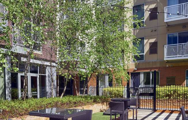 an outdoor patio with tables and chairs in front of an apartment building