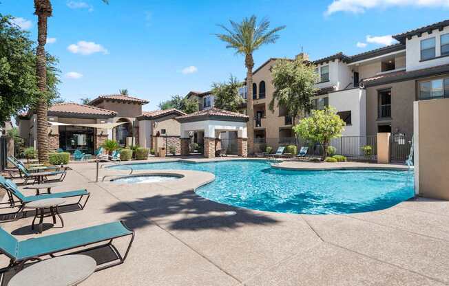 A pool surrounded by lounge chairs and palm trees.