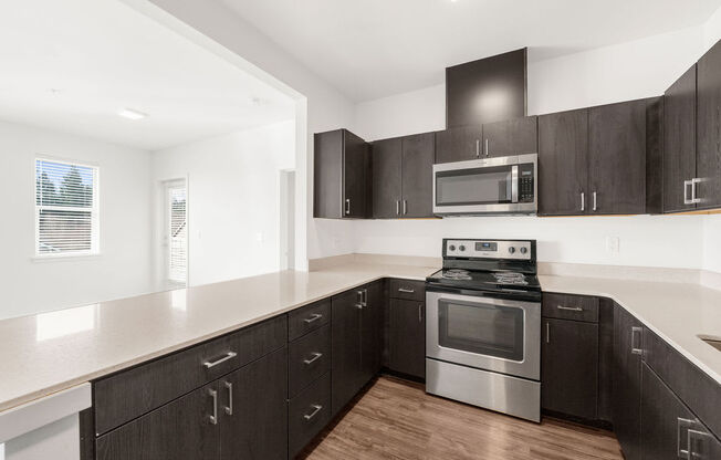 a kitchen with dark cabinets and white countertops