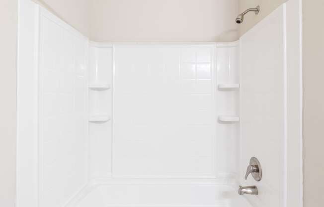 a white bathroom with a shower and a sink