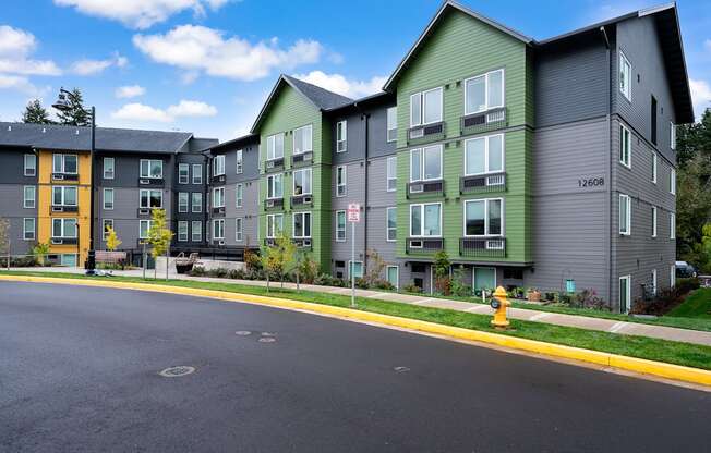 an empty street with an apartment building and a yellow fire hydrant