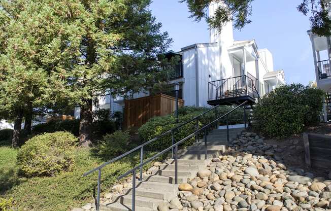 View from lower level of well landscaped exterior of building with private patio/balcony