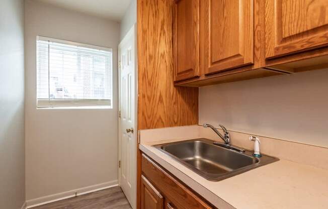 A kitchen with wooden cabinets and a white sink.