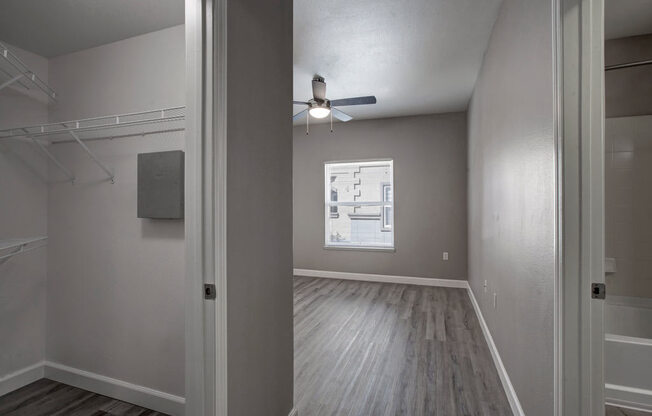 an empty bedroom with a ceiling fan