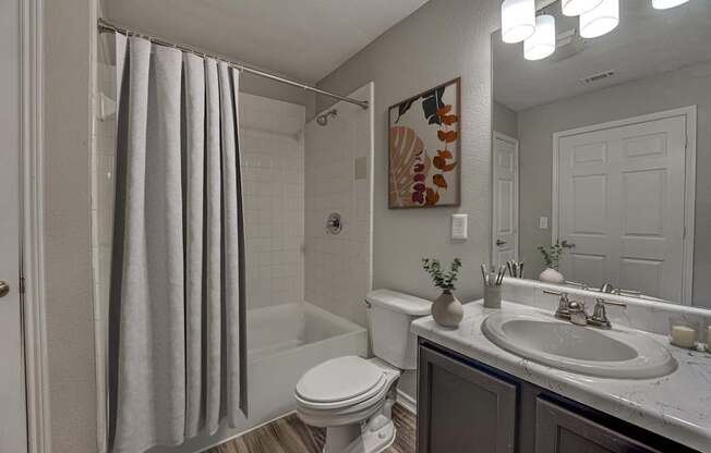 A bathroom with a toilet, sink, and shower.