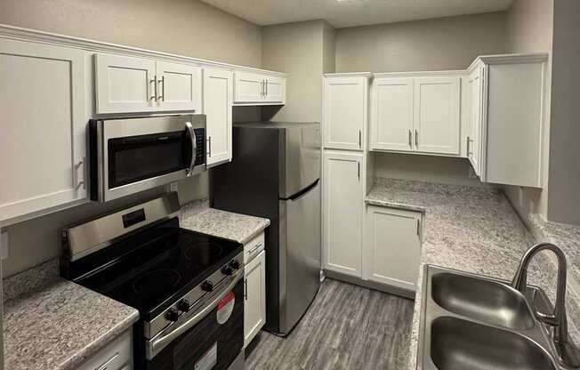 A kitchen with black appliances and white cabinets.