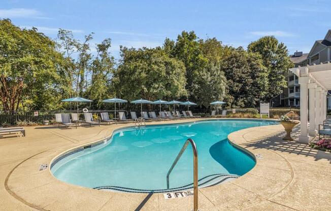 a swimming pool with umbrellas next to a building at Marina Point, Chattanooga, TN 37415