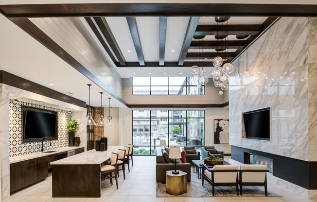 the lobby of a hotel with couches and chairs and a fireplace