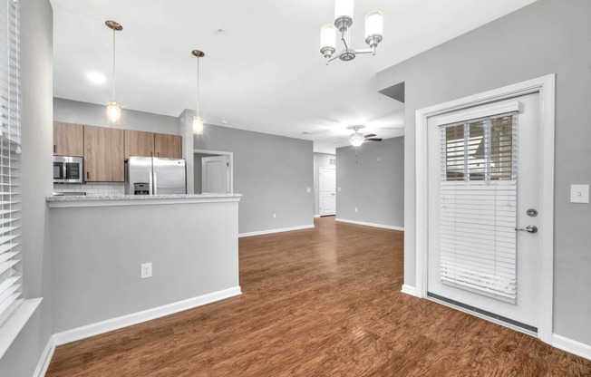 an open living room and kitchen with a door to the kitchen