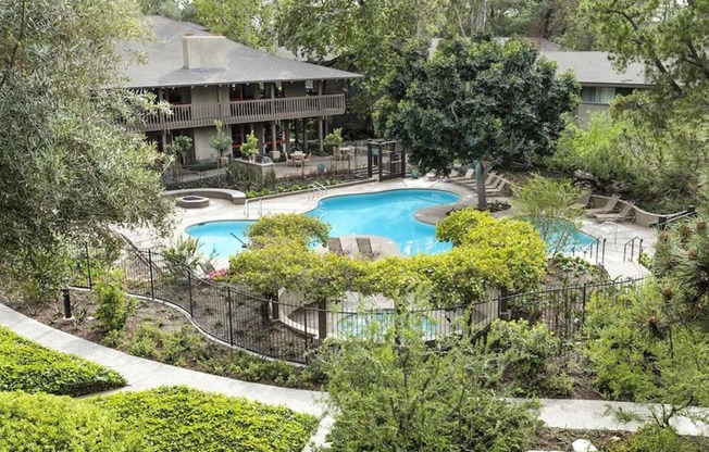 an aerial view of the backyard of a house with a swimming pool