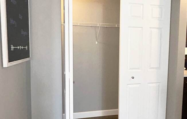 A white door is open to a room with a chalkboard on the wall.
