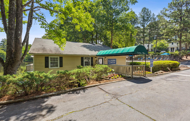 a yellow building with a green roof and a parking lot