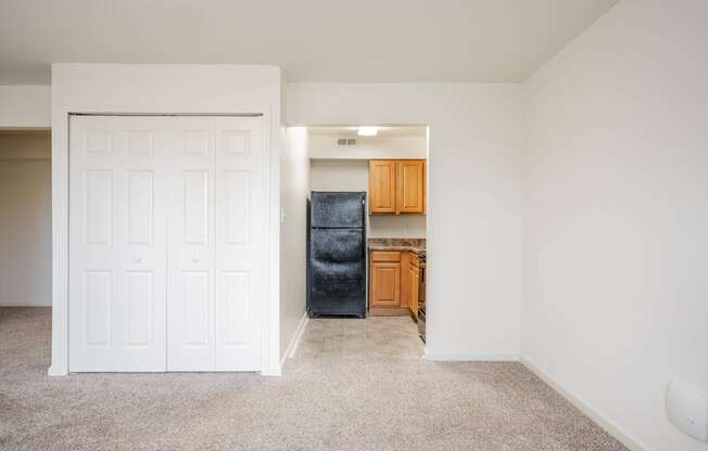 A white door is on the left and a black fridge is on the right.