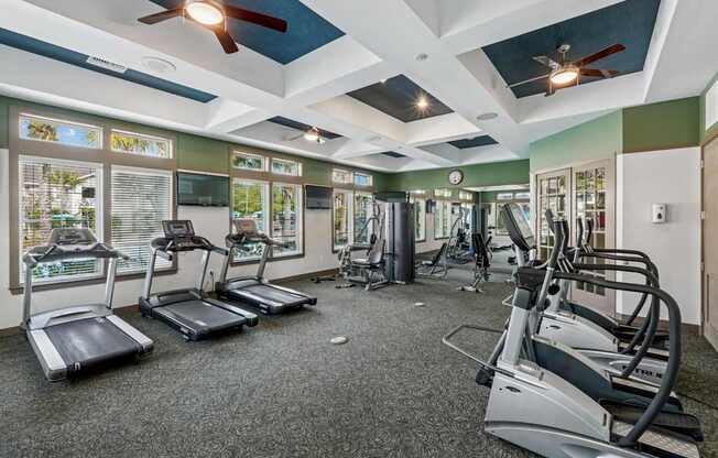 A gym with treadmills, elliptical machines, and other exercise equipment.