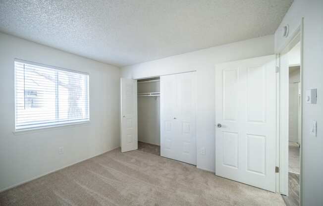 an empty bedroom with a closet and a window at Kirkwood in Pocatello, ID