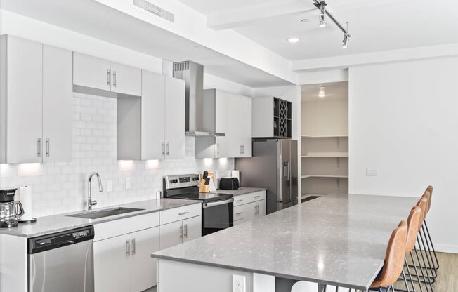 A modern kitchen with white cabinets and appliances.
