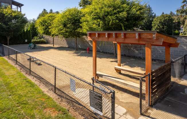 a dog park with a fenced in area and a bench