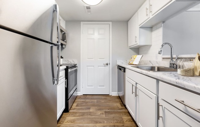 Reserve at Providence Apartment in Charlotte NC photo of a kitchen with white cabinets and stainless steel appliances