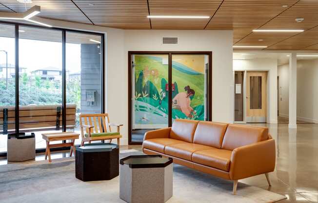 a living room with a large painting and a leather couch