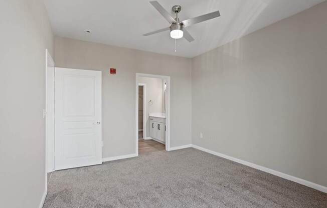 Flatiron West Trade Apartments gray carpeted bedroom with attached bathroom and walk-in closet