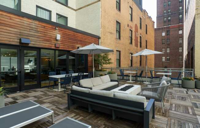 a patio with couches tables and chairs and umbrellas at The Commonwealth Building, Pittsburgh, 15222