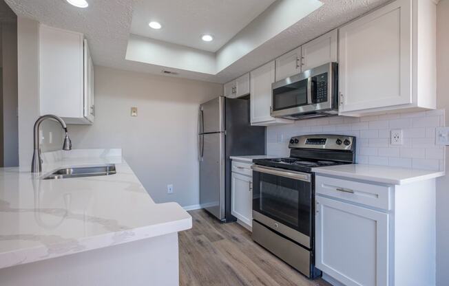 Perimeter Lakes apartments kitchen with white cabinets and stainless appliances