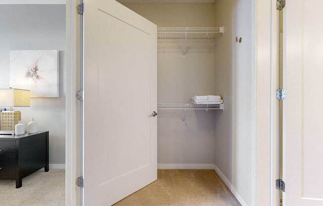 A white door is open to a small closet with a shelf.