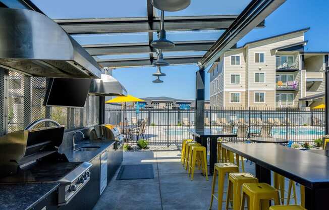 a kitchen with bar stools and a view of a pool and buildings