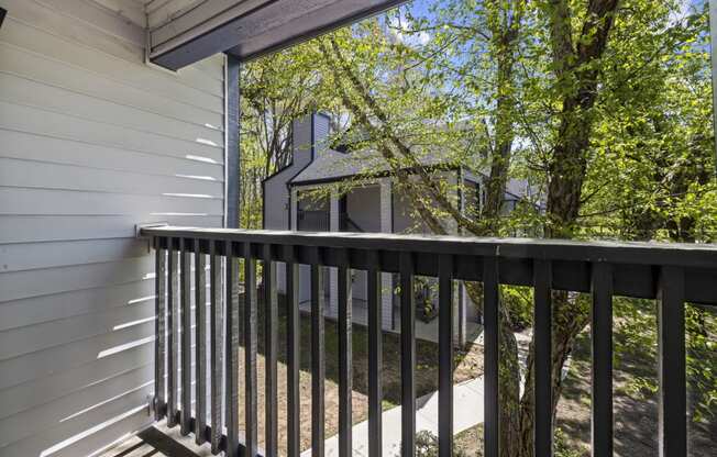 a balcony with a view of apartments and trees