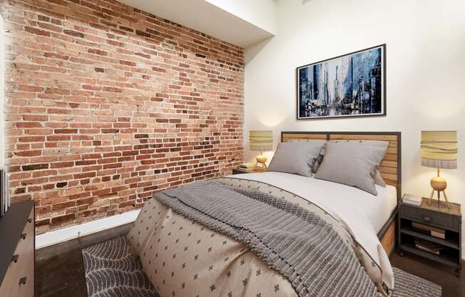 a bedroom with a bed and an exposed brick wall