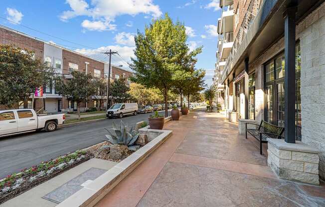 an empty sidewalk in front of a building on a city street