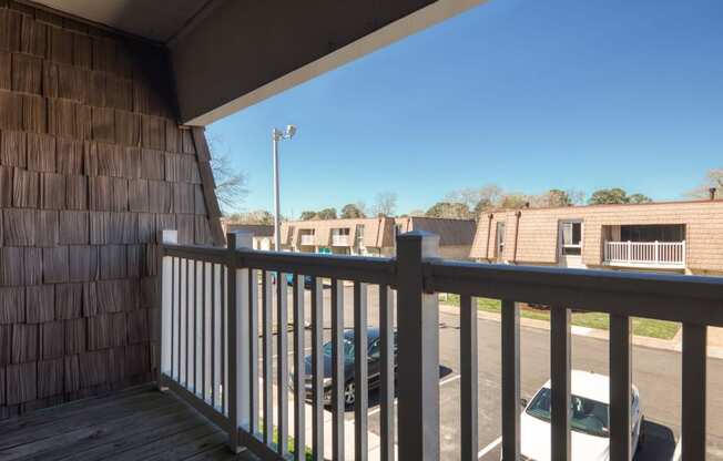 a view from the balcony of a building with a car in the parking lot  at Bayville Apartments, Virginia Beach, VA, 23455