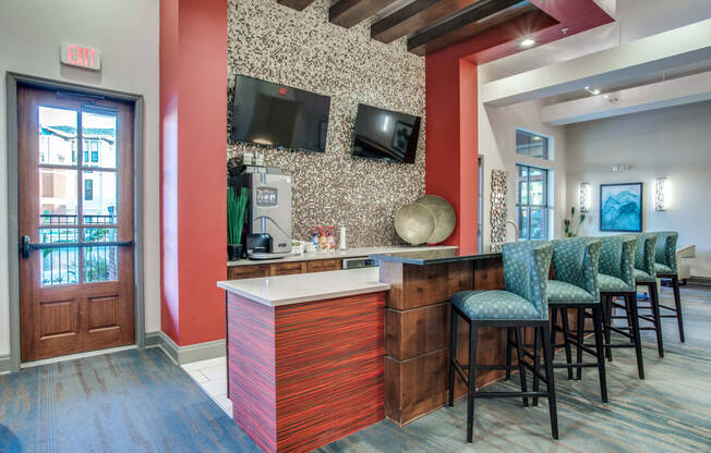 a lobby with a bar and chairs and a television