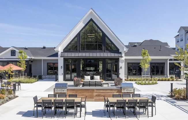 a patio with tables and chairs in front of a building