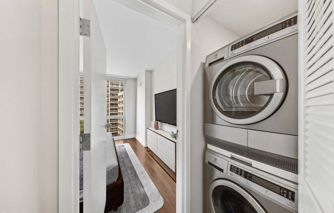a laundry room with a washer and dryer and a door to a hallway